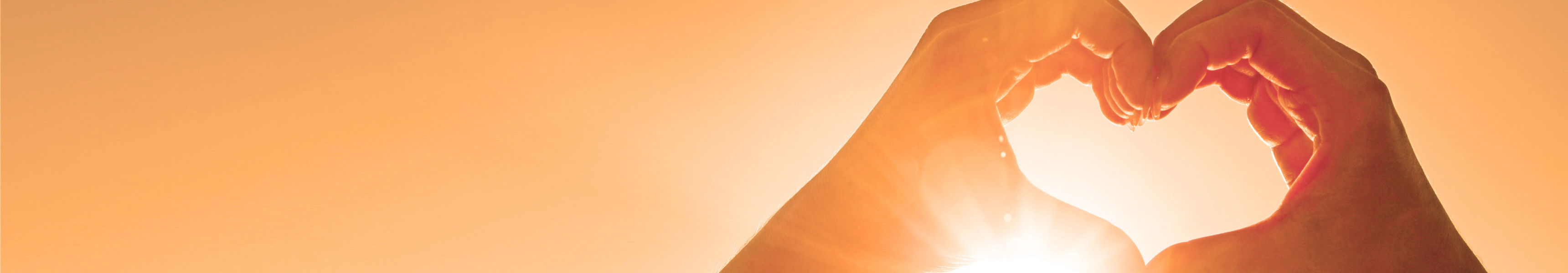 &auml;nde formen ein Herz vor der Sonne bei goldenem Abendhimmel