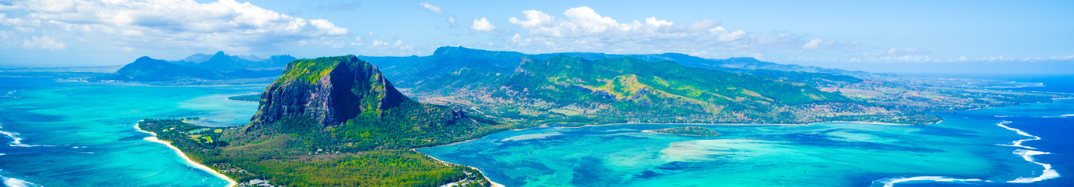 Atemberaubende Luftaufnahme von Le Morne Brabant auf Mauritius, umgeben von türkisfarbenem Wasser und dem berühmten „Unterwasser-Wasserfall“-Effekt im Indischen Ozean.