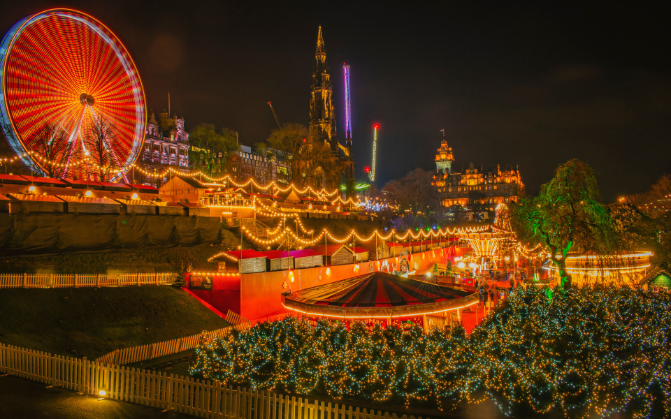 Festlich beleuchtetes Edinburgh Winter Festival mit funkelnden Lichterketten, einem leuchtenden Riesenrad und stimmungsvoller Weihnachtsmarkt-Atmosph&auml;re in der historischen Altstadt.